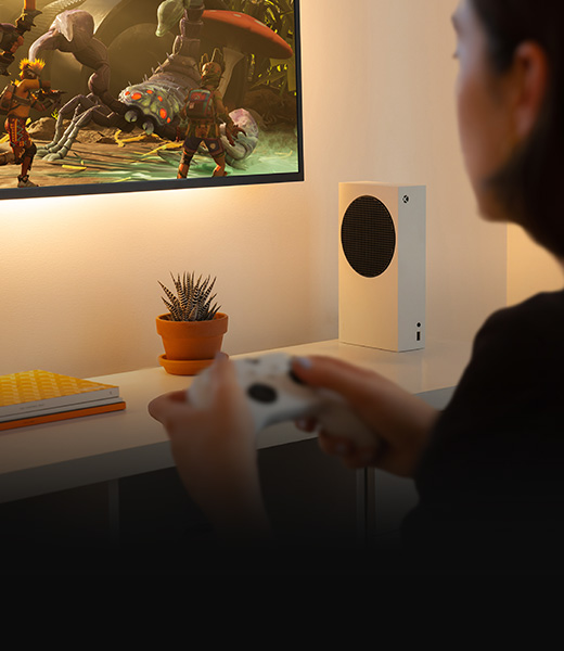 Seitenansicht einer Person, die auf der XBOX Series S spielt, mit Spiel-Action auf einem TV-Gerät.