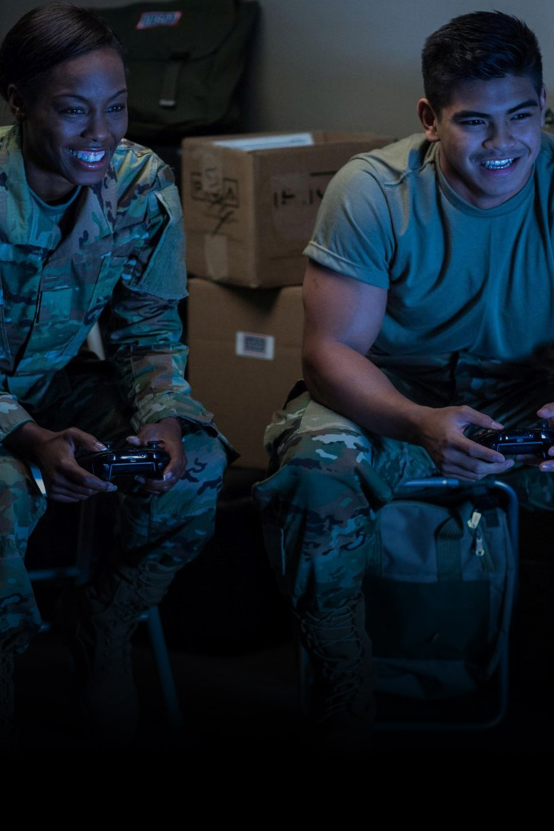 Two people in military uniforms playing on an Xbox. 