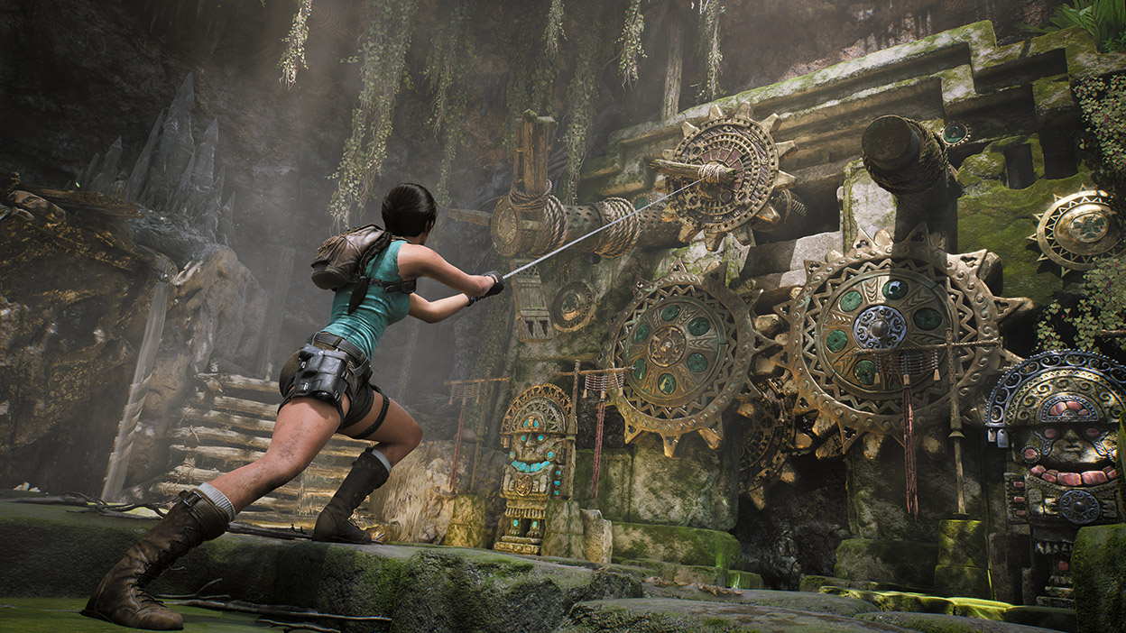 Lara Croft pulls a rope on an ornate cog puzzle in a mossy temple.