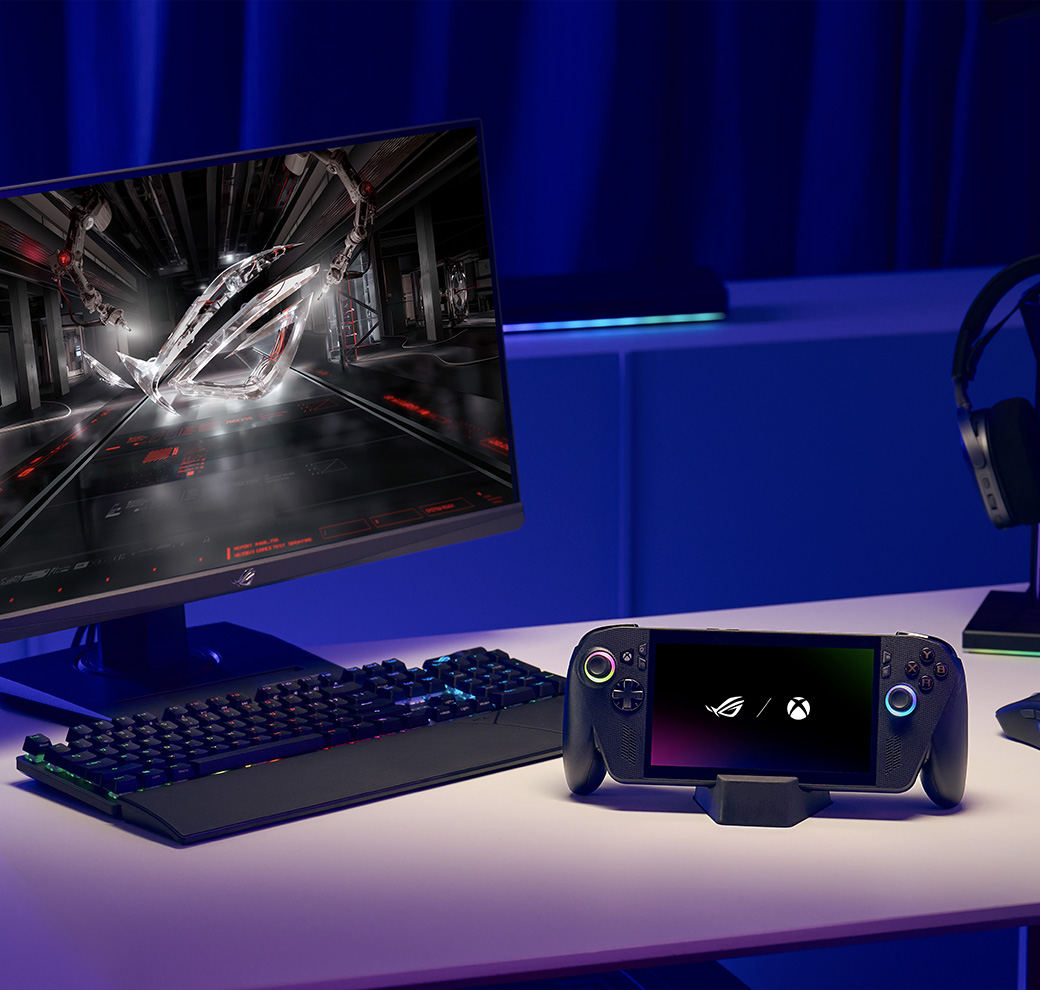 ROG Xbox Ally X on a stand next to a computer monitor and keyboard