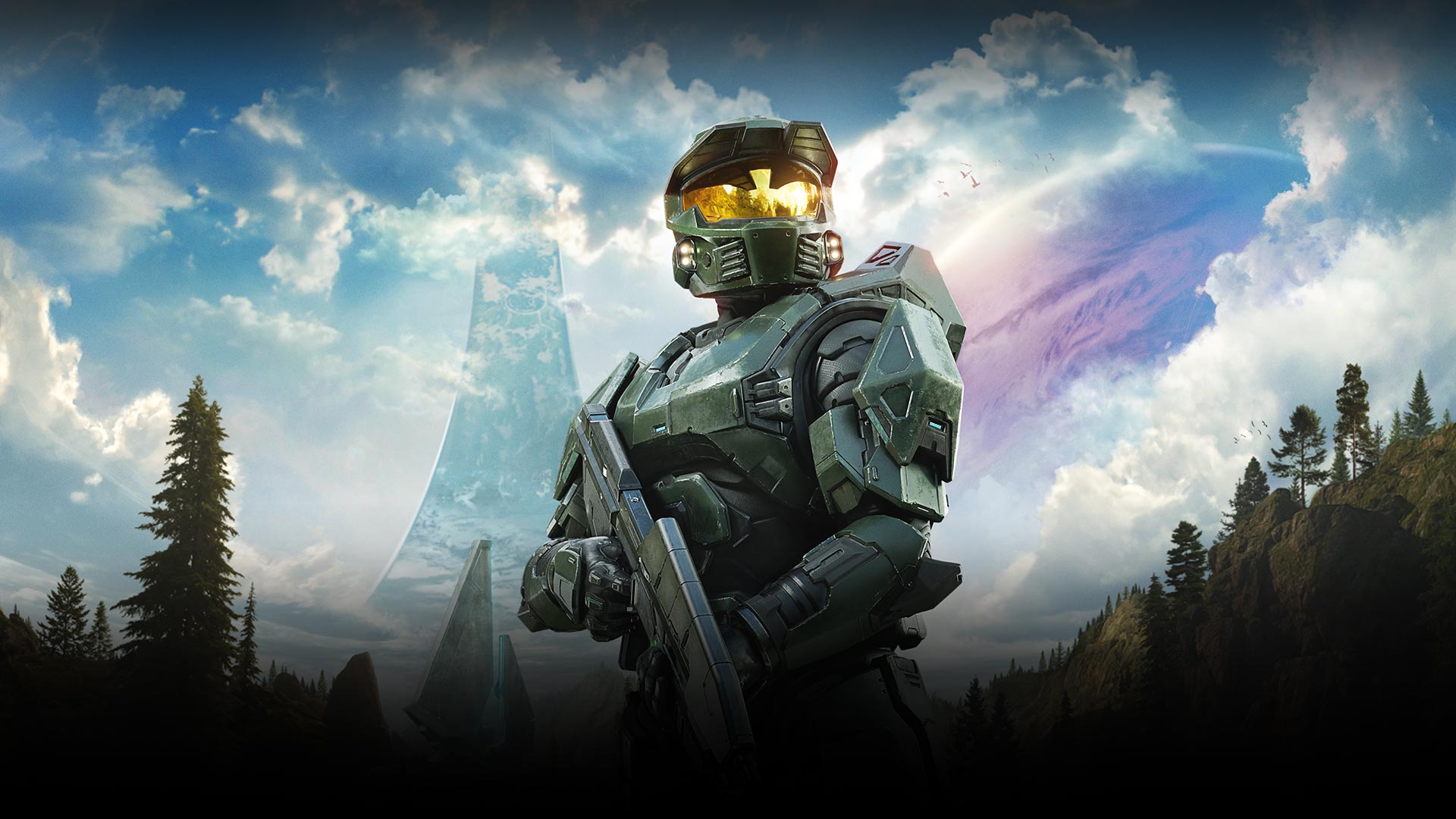 The Master Chief stands holding his weapon with a large futuristic building and a huge planet in the sky in the background.