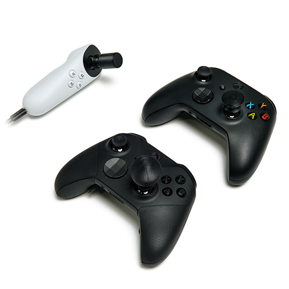 Différentes tailles et formes de capuchons de joysticks adaptatifs sur un joystick adaptatif Xbox et deux manettes sans fil Xbox.