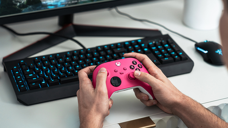 Person holding a Xbox Wireless Controller over a keyboard