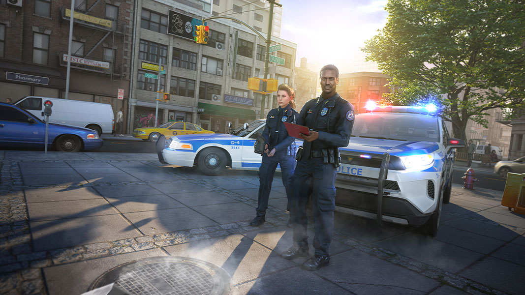 A male and female police officer standing in front of police cars with emergency lights flashing.