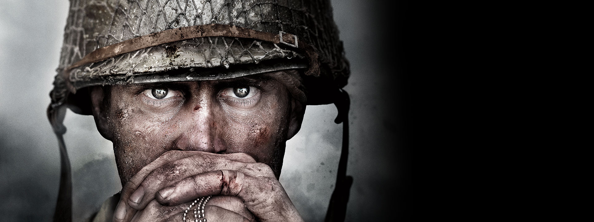 A tattered World War 2 soldier stares intensely as he clutches his dog tags 