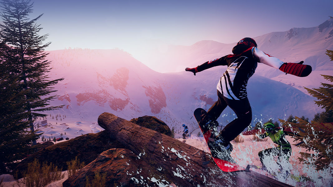 A snowboarder jumping off of a log down a mountainous snowy landscape. 