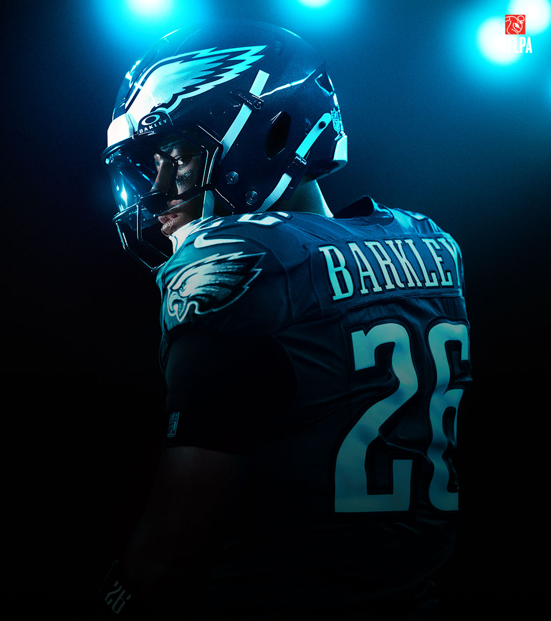 NFLPA Logo, Philadelphia Eagles player Saquon Barkley looks over his shoulder in a glow of neon lights