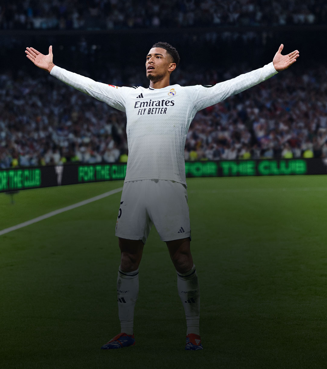 A soccer player standing on the field in front of a large crowd with his arms held out.
