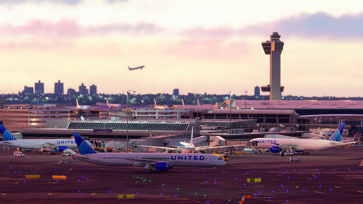 Anochecer en un aeropuerto con aviones comerciales estacionados en sus terminales. 