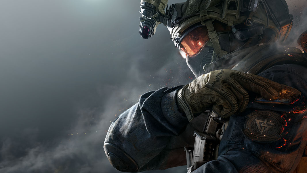A well equipped and masked soldier tapping their left shoulder looking left. 