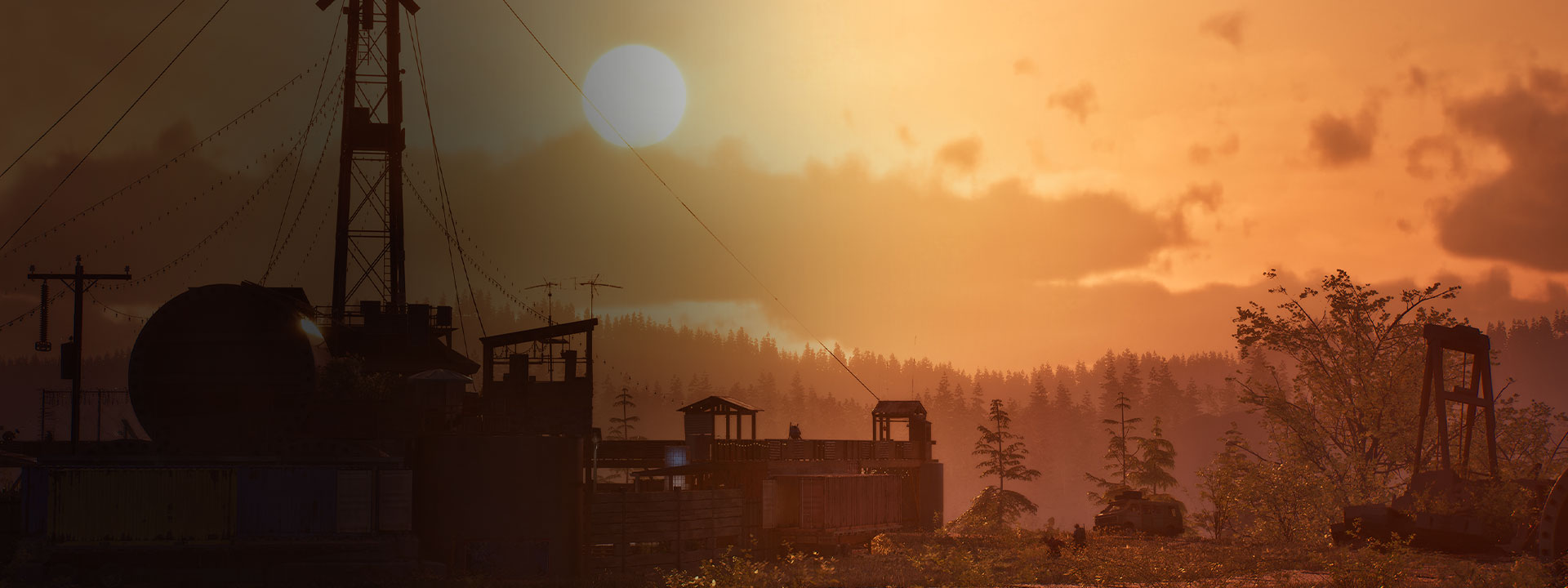 A golden sunset over a compound with a forest in the distance.