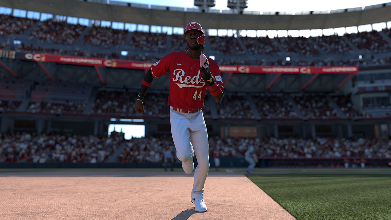 Elly De la Cruz in a number 44 Cincinnati Reds Jersey running from one base to the next.
