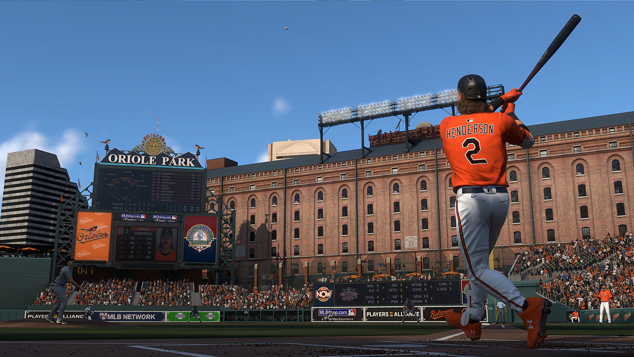 Gunner Henderson wearing a number 2 Baltimore Orioles jersey hitting a ball high into the sky.