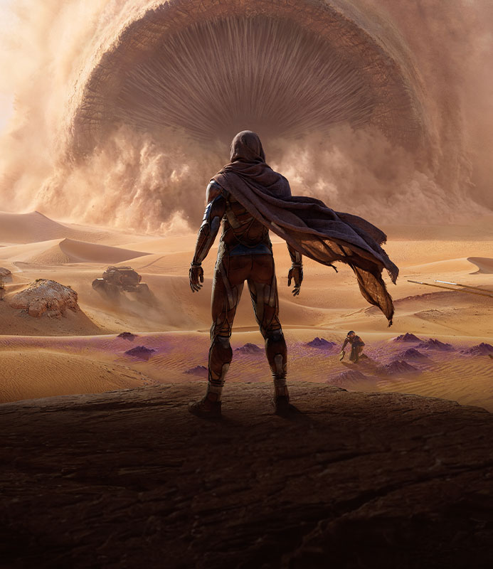 Dune : Awakening, un personnage solitaire vêtu d'une cape se tient dans un vaste canyon désertique et fait face à un ver de sable colossal émergeant d'un énorme nuage de sable tourbillonnant.