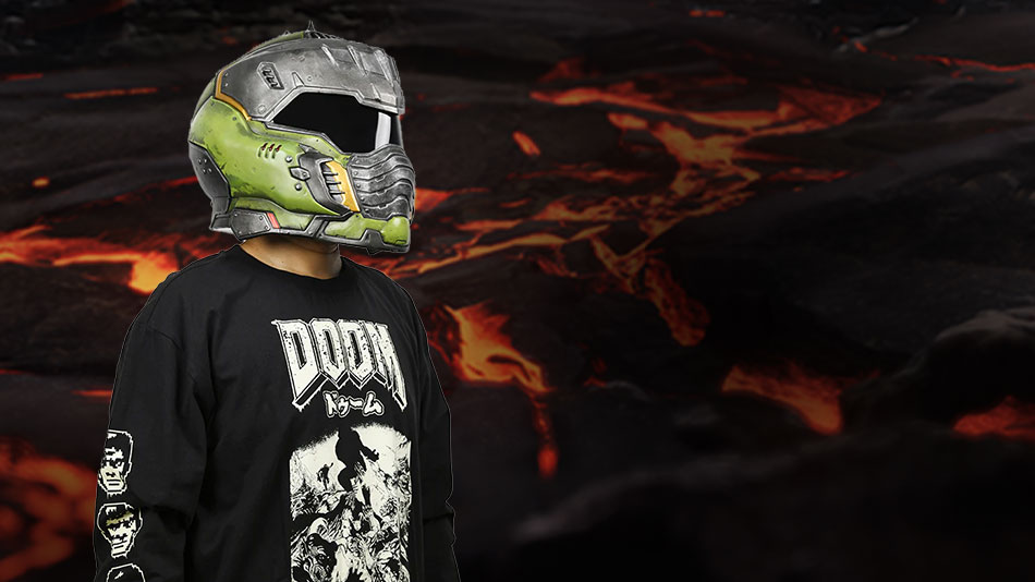 A person wearing a green and silver DOOM: The Dark Ages helmet and DOOM t-shirt